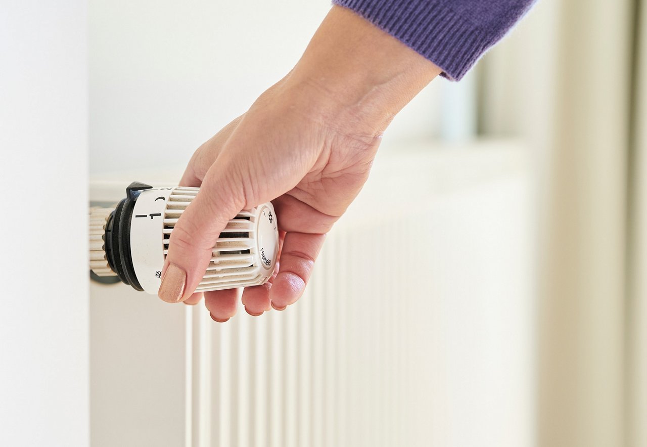 Frauenhand am Thermostatkopf