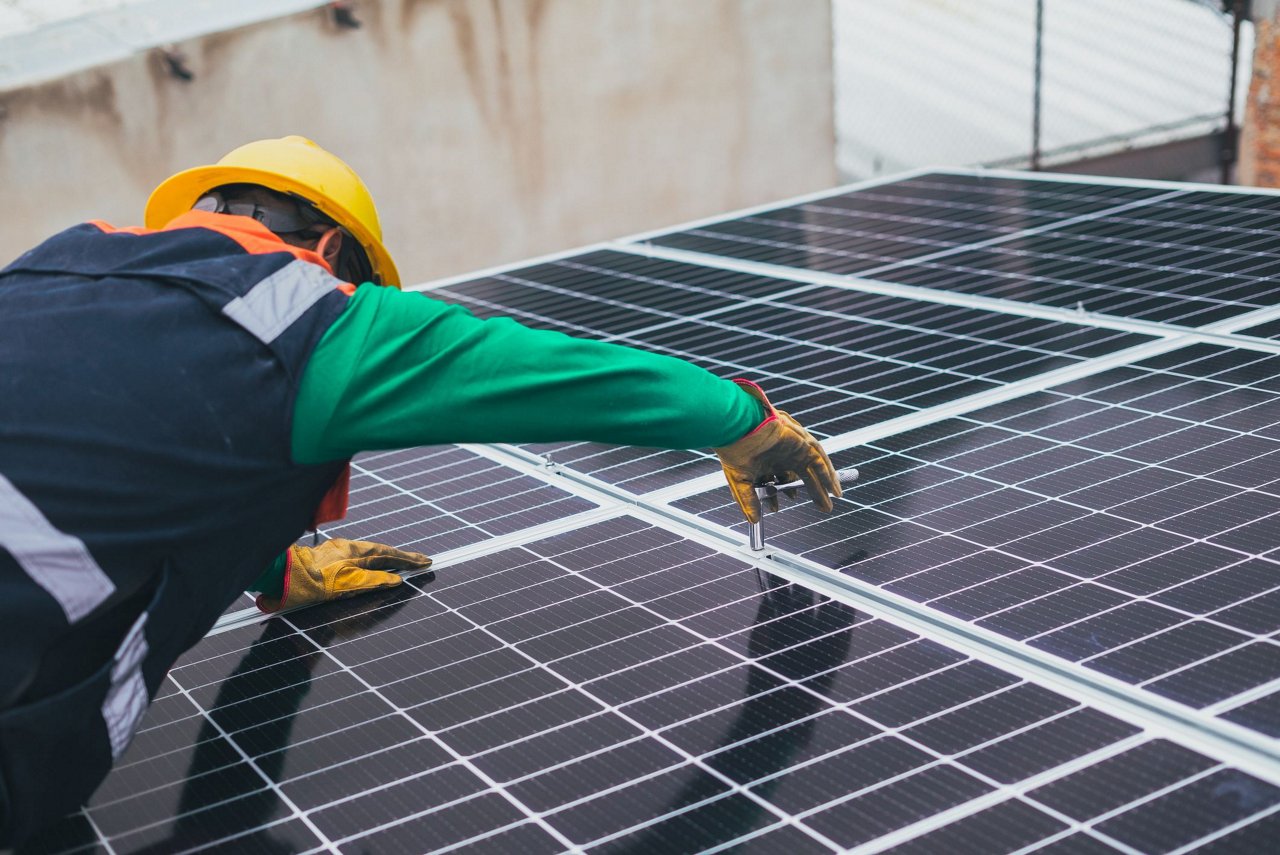 Solarpaneltechniker überprüft Solarpaneele auf dem Dach