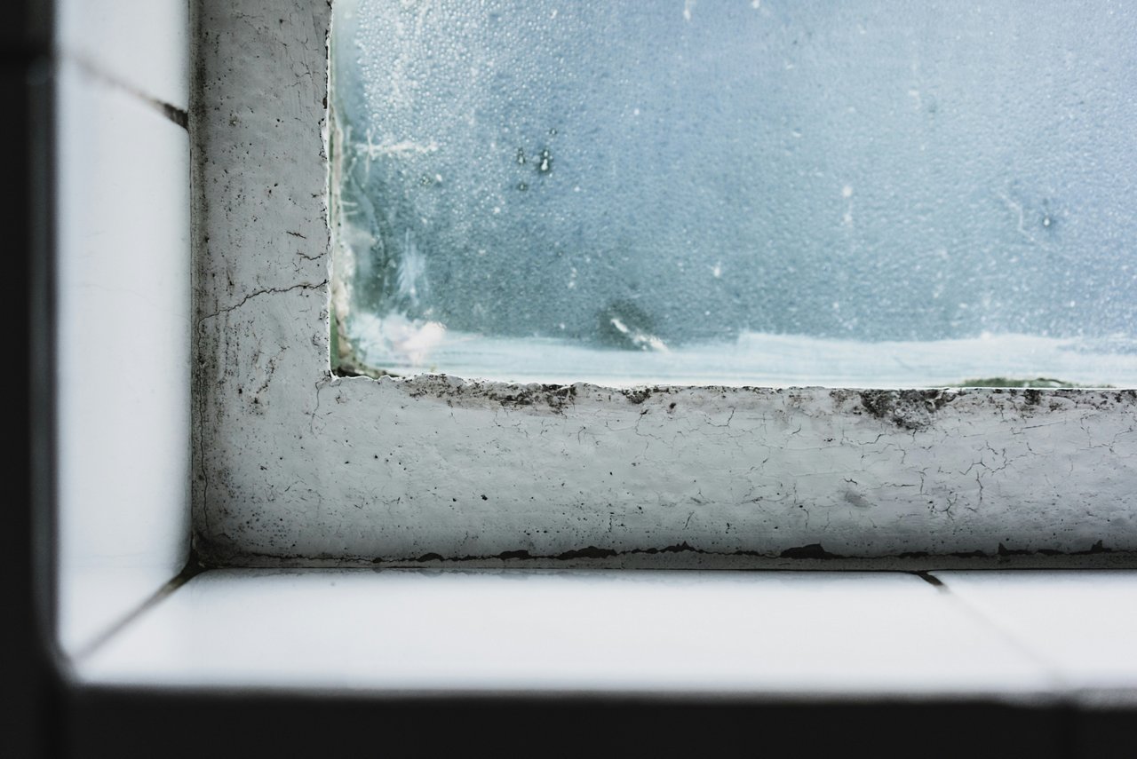 Ausschnitt von einem kleinen Fenster mit Schmmelbildung