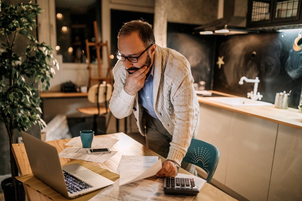 Men in kitchen, resolving problem with bills