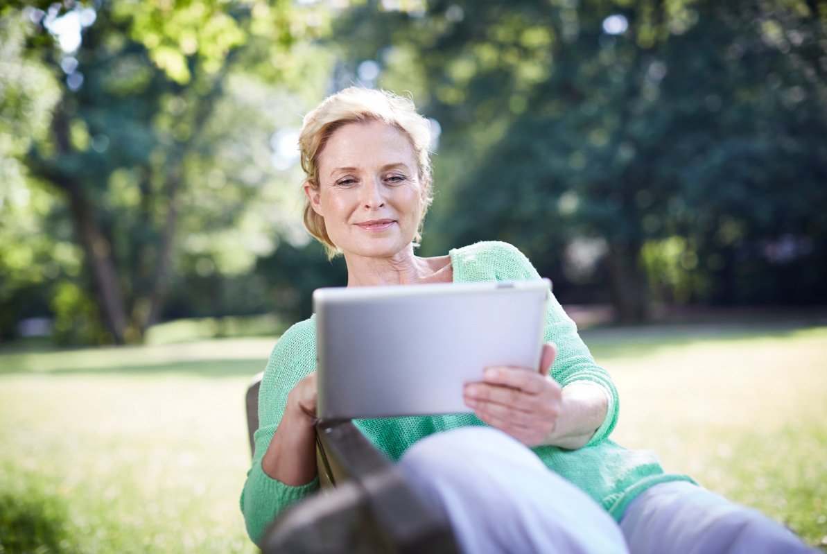 Frau im Garten mit Checkliste für Vermieter auf Tablet